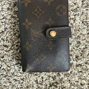Louis Vuitton bifold wallet with monogram pattern.